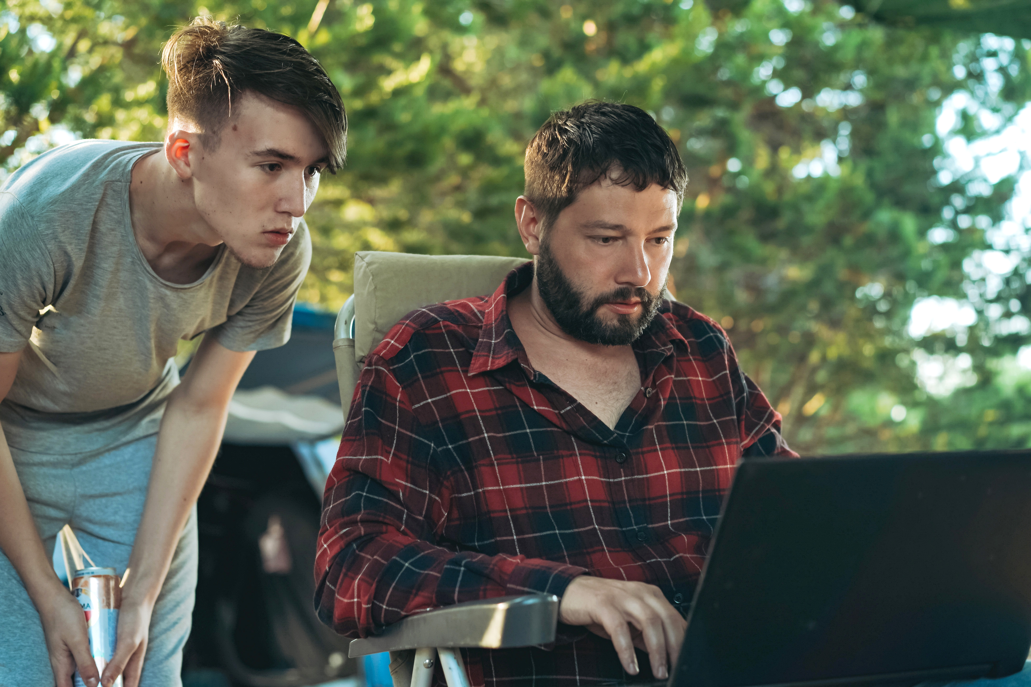 Caucasian bearded man and teenage son working